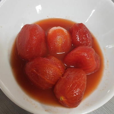 Deliziosi pomodori in scatola di sapore dolce, sbucciati con la materia prima più fresca